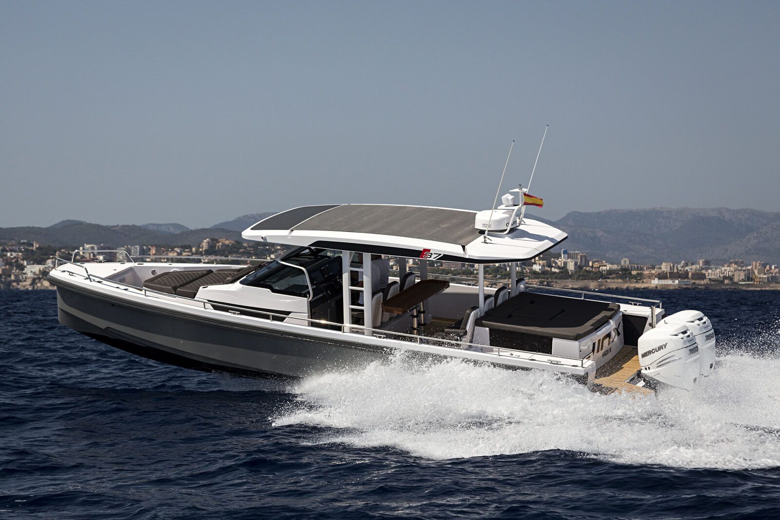 Axopar 37 T-Top rear view showing aft sunbed, seating and Mercury engines cruising Mallorca