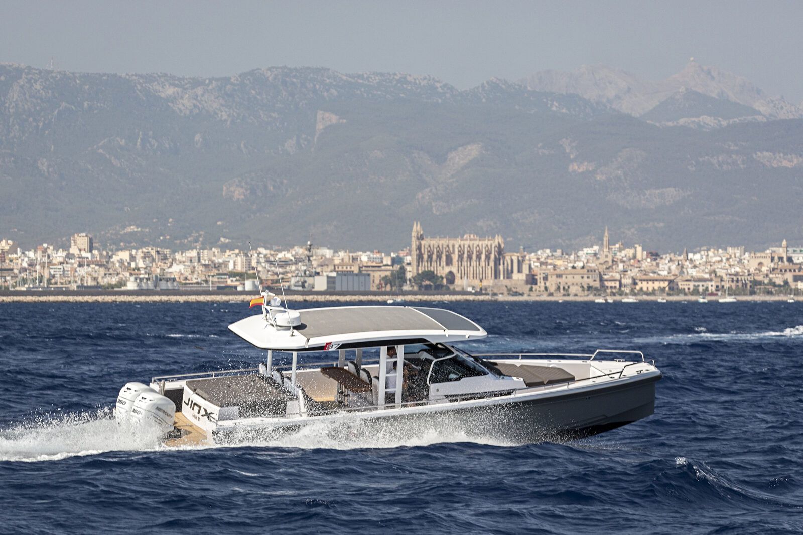 Axopar 37 charter boat cruising past Palma Cathedral, Mallorca
