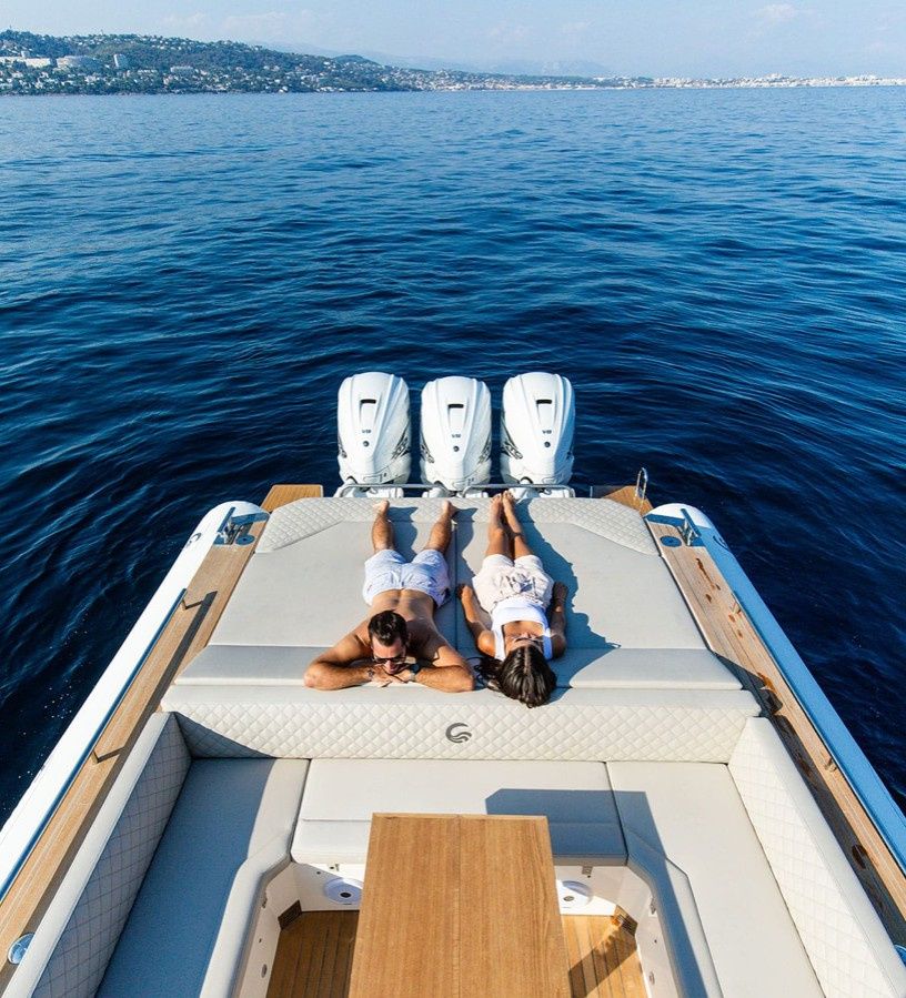 Tempest 44 aft deck sunbed with guests relaxing during boat charter
